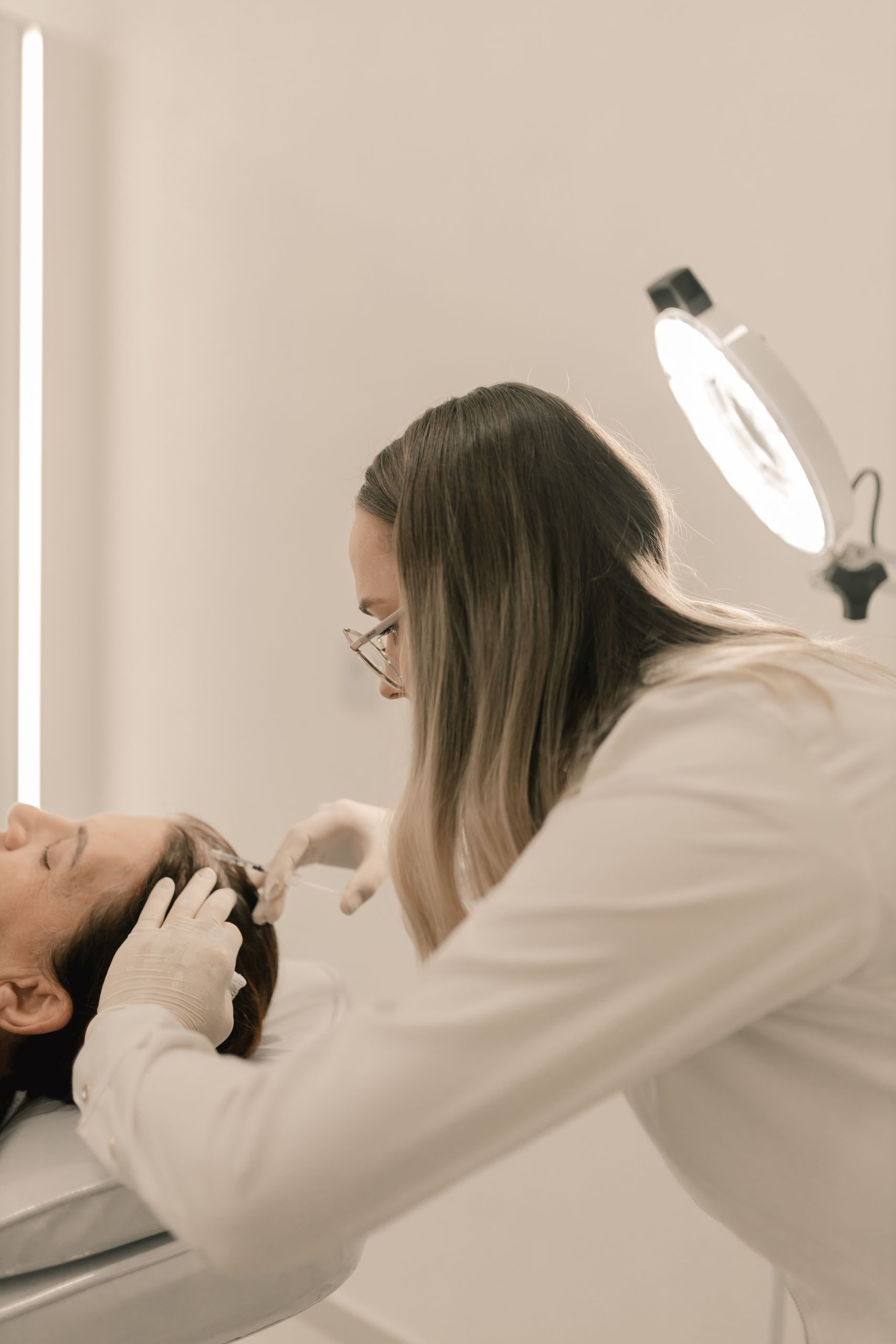 Médica a avaliar um tratamento capilar com equipamento especializado